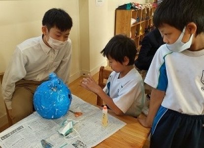 小学生が中学生のお兄さん・おねえさんと一緒にお面を作成しました。