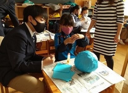 小学生が中学生のお兄さん・おねえさんと一緒にお面を作成しました。